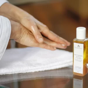 Foto de mãos espalhando Óleo Esfoliante com Sal do Himalaia, cosmético natural de beleza